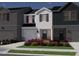 Charming two-story townhome featuring a light gray exterior, blue shutters, and a welcoming front yard at 1045 Winding Spring Dr, Mebane, NC 27302