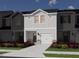 Charming two-story townhome with white siding, brick accents, a front-facing garage, and landscaping at 1047 Winding Spring Dr, Mebane, NC 27302
