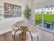Dining area featuring a round wooden table, stylish chairs, and views of the backyard through a sliding door at 1049 Winding Spring Dr, Mebane, NC 27302