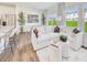Sunlit living room with plush white sofa, modern decor, and wood flooring, open to dining area at 1049 Winding Spring Dr, Mebane, NC 27302