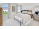 Serene main bedroom featuring a plush bed, neutral tones, and soft carpeting with views of the backyard at 1049 Winding Spring Dr, Mebane, NC 27302