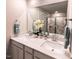 Bathroom featuring double sinks, quartz counters, and a tiled shower with glass door at 1053 Winding Spring Dr, Mebane, NC 27302