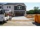 New construction with two-car garage, neutral colors, and landscaping in progress on a sunny day at 1053 Winding Spring Dr, Mebane, NC 27302