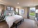 Serene main bedroom featuring a large bed, neutral decor, bedside tables, and natural light from windows at 1053 Winding Spring Dr, Mebane, NC 27302