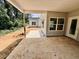 Covered porch with gray siding, large concrete patio, and wooded backdrop at 1085 Fairhaven Dr # 49, Mebane, NC 27302