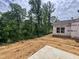 Unfinished backyard of a new construction home, surrounded by lush trees and foliage at 1085 Fairhaven Dr # 49, Mebane, NC 27302