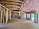 Unfinished basement with visible framing, pink insulation, stairs, and door to outside at 1085 Fairhaven Dr # 49, Mebane, NC 27302