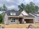 Exterior view of a new home under construction, featuring a brick facade and garage framing at 1085 Fairhaven Dr # 49, Mebane, NC 27302