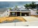 New construction home featuring gray brick, a dormer window, and an attached two-car garage at 1085 Fairhaven Dr # 49, Mebane, NC 27302