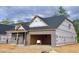 New construction home showcasing a brick facade and garage framing, under a cloudy sky at 1085 Fairhaven Dr # 49, Mebane, NC 27302