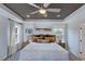 Primary bedroom boasts a tray ceiling, large windows, and stylish decor at 1125 Sun Springs Rd, Wake Forest, NC 27587