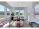 Bright sunroom features neutral decor, large windows with wooded views, and a seating area with plush chairs at 1125 Sun Springs Rd, Wake Forest, NC 27587