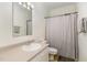 Well-lit bathroom featuring a vanity sink, toilet, and shower with neutral colors and towels at 1176 Stoney Mountain Rd, Rougemont, NC 27572