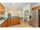 Open kitchen with wooden cabinets, stainless steel refrigerator, and pantry at 1176 Stoney Mountain Rd, Rougemont, NC 27572