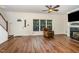 Cozy living room showcasing hardwood floors, fireplace, and large windows for natural light at 1176 Stoney Mountain Rd, Rougemont, NC 27572