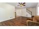 Well-lit living room with hardwood floors leading to a dining area and staircase, complemented by a cozy chair at 1176 Stoney Mountain Rd, Rougemont, NC 27572