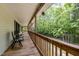 Relax on this covered porch with wood railings and plenty of space to unwind and enjoy wooded views at 1176 Stoney Mountain Rd, Rougemont, NC 27572