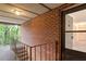 Upstairs hallway with painted brick walls leads to entry door at 1217 Manassas Ct # H, Raleigh, NC 27615