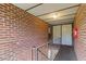Upstairs Hallway with brick walls leads to entry door at 1217 Manassas Ct # H, Raleigh, NC 27615