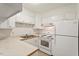 Cozy kitchen with white appliances, cabinets, and countertops offers a quaint space to cook at 1217 Manassas Ct # H, Raleigh, NC 27615
