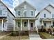 Charming two-story home with a welcoming front porch and a delightful pink front door at 127 Mossy Falls Way, Wendell, NC 27591