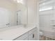 Bright bathroom features a white vanity with quartz countertop and a tub/shower combo with white surround at 149 Whimbrel Ct, Lillington, NC 27546