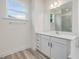 White vanity, a large mirror, and a window that offers natural light in bathroom at 149 Whimbrel Ct, Lillington, NC 27546
