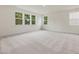 Large bedroom featuring plush carpeting, three windows, and natural light at 149 Whimbrel Ct, Lillington, NC 27546