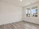 Bright bedroom featuring light wood floors, white walls, and two large windows at 149 Whimbrel Ct, Lillington, NC 27546