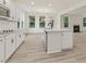 New kitchen with white cabinets, island, stainless appliances, and view to breakfast nook and living room at 149 Whimbrel Ct, Lillington, NC 27546