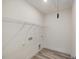 Bright laundry room features wooden floors, wire shelving, and hook to access the attic at 149 Whimbrel Ct, Lillington, NC 27546