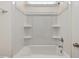Bright bathtub and shower combo with white surround and built-in shelves at 149 Whimbrel Ct, Lillington, NC 27546