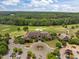 Aerial view of a grand clubhouse surrounded by lush landscaping and a meticulously maintained golf course at 1620 Hasentree Villa Ln, Wake Forest, NC 27587