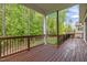 Covered deck with wooden floors and railings providing a serene outdoor space with wooded views at 1620 Hasentree Villa Ln, Wake Forest, NC 27587