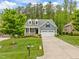 Inviting blue home with a manicured lawn, a two-car garage, and charming curb appeal at 1620 Hasentree Villa Ln, Wake Forest, NC 27587