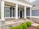 Welcoming covered front porch with white columns, stone accents, and a view of the landscaped yard at 1620 Hasentree Villa Ln, Wake Forest, NC 27587
