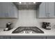 Modern kitchen featuring stainless steel appliances, gray cabinets, and a stylish range hood at 1620 Hasentree Villa Ln, Wake Forest, NC 27587