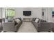 Symmetrical living room with matching gray sofas, a modern media center, and a view to the porch at 1620 Hasentree Villa Ln, Wake Forest, NC 27587
