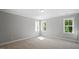 Bright bedroom featuring neutral carpet, three windows, and fresh, neutral paint at 1733 Birdhaven Ln # 2217, Wendell, NC 27591