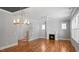 Open living room featuring a fireplace, staircase, hardwood floors, and elegant light fixture at 1733 Birdhaven Ln # 2217, Wendell, NC 27591