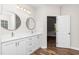 Bathroom featuring double sinks, modern round mirrors, and durable wood-look flooring at 186 N Ashe Ave, Dunn, NC 28334