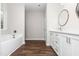 Bathroom with long white vanity, modern round mirrors, a separate tub, and wood-look flooring at 186 N Ashe Ave, Dunn, NC 28334