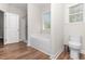 Spacious bathroom featuring a separate shower, tub, commode and wood-look flooring at 186 N Ashe Ave, Dunn, NC 28334