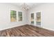 Dining area with stylish light fixture, wood floors, neutral walls, and double doors at 186 N Ashe Ave, Dunn, NC 28334