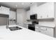 Bright kitchen with stainless steel sink, black appliances, white cabinets and marble countertops at 186 N Ashe Ave, Dunn, NC 28334