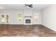 Open living room with a fireplace, ceiling fan, light-filled windows and wood-look flooring at 186 N Ashe Ave, Dunn, NC 28334