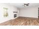Cozy living room with a fireplace, ceiling fan, light-filled windows and wood-look flooring at 186 N Ashe Ave, Dunn, NC 28334