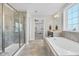 Bright bathroom with tiled floor, soaking tub beneath large window, and separate glass-enclosed shower at 2008 Campana Dr, Raleigh, NC 27603
