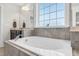 Bright bathroom with tiled floor with soaking tub and granite surround beneath a bright window at 2008 Campana Dr, Raleigh, NC 27603