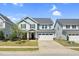Charming two-story home featuring light blue siding, stone accents, a two-car garage, and a well-maintained lawn at 2008 Campana Dr, Raleigh, NC 27603